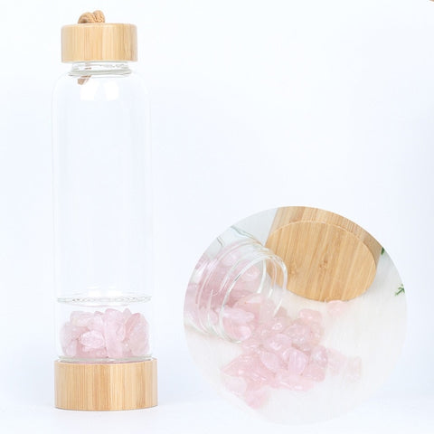 Glass and bamboo water bottle with rose quartz crystals.